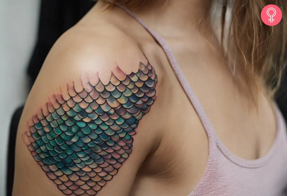 A realistic mermaid scales tattoo on a woman’s upper arm