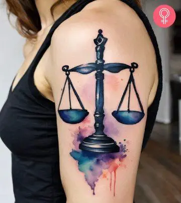 A female lawyer stands with crossed arms with a tattoo