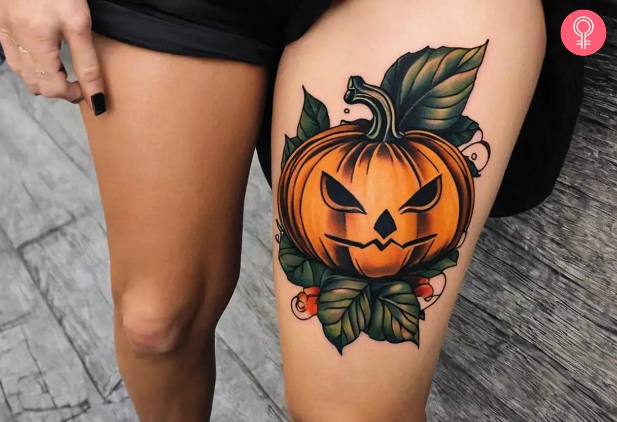 A scary pumpkin tattoo on the thigh of a woman