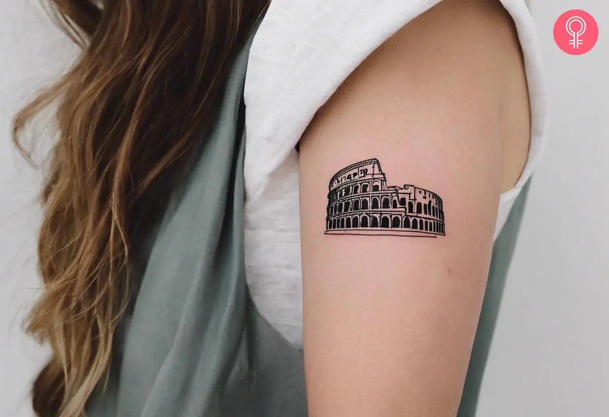 A simple colosseum tattoo on the upper arm of a woman