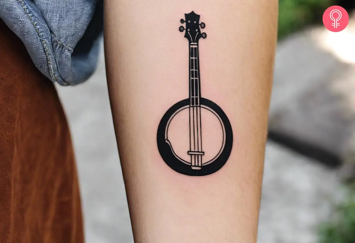 A simple yet charming banjo tattoo on the forearm