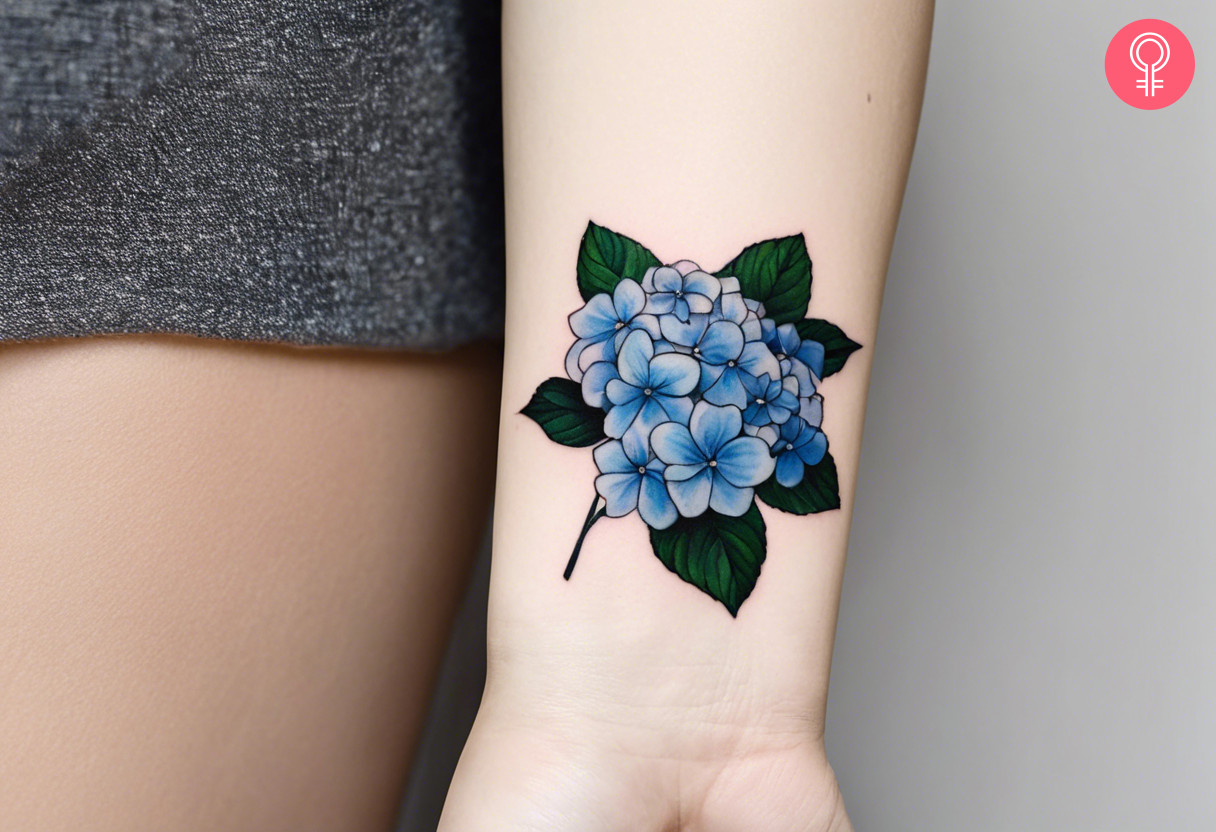 A small hydrangea tattoo on the wrist of a woman