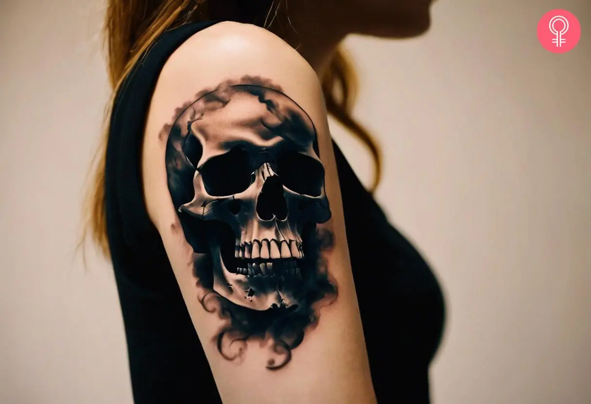 A smoke skull tattoo on a woman’s upper arm