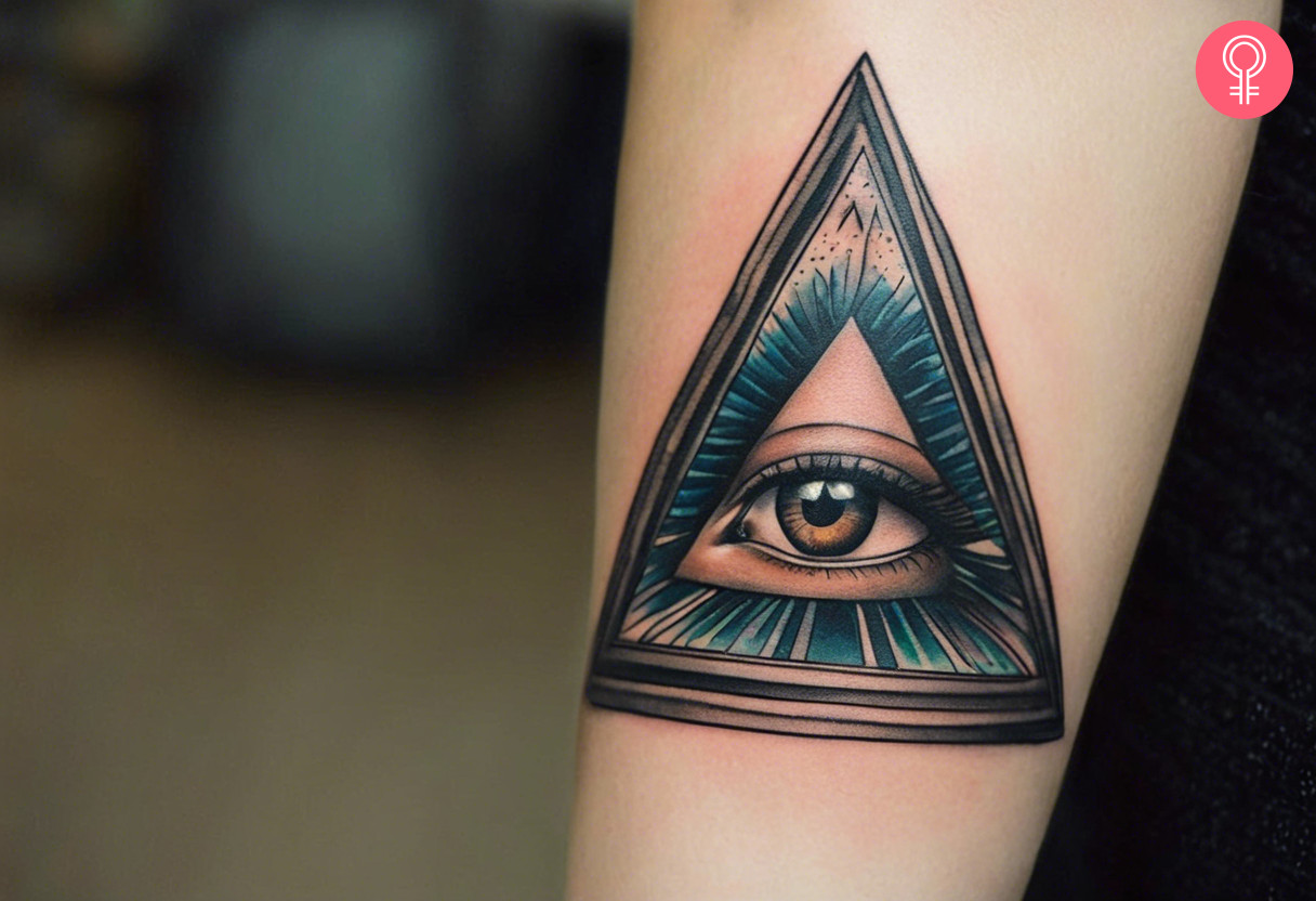 A traditional Brown Eye Illuminati tattoo on the upper arm