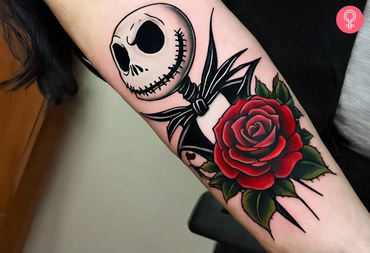 A traditional Jack Skellington with red rose tattoo on the forearm