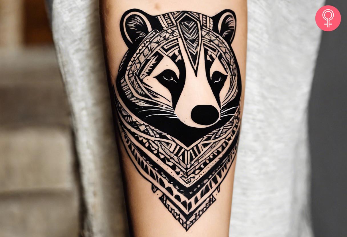 A tribal badger head tattoo on the forearm