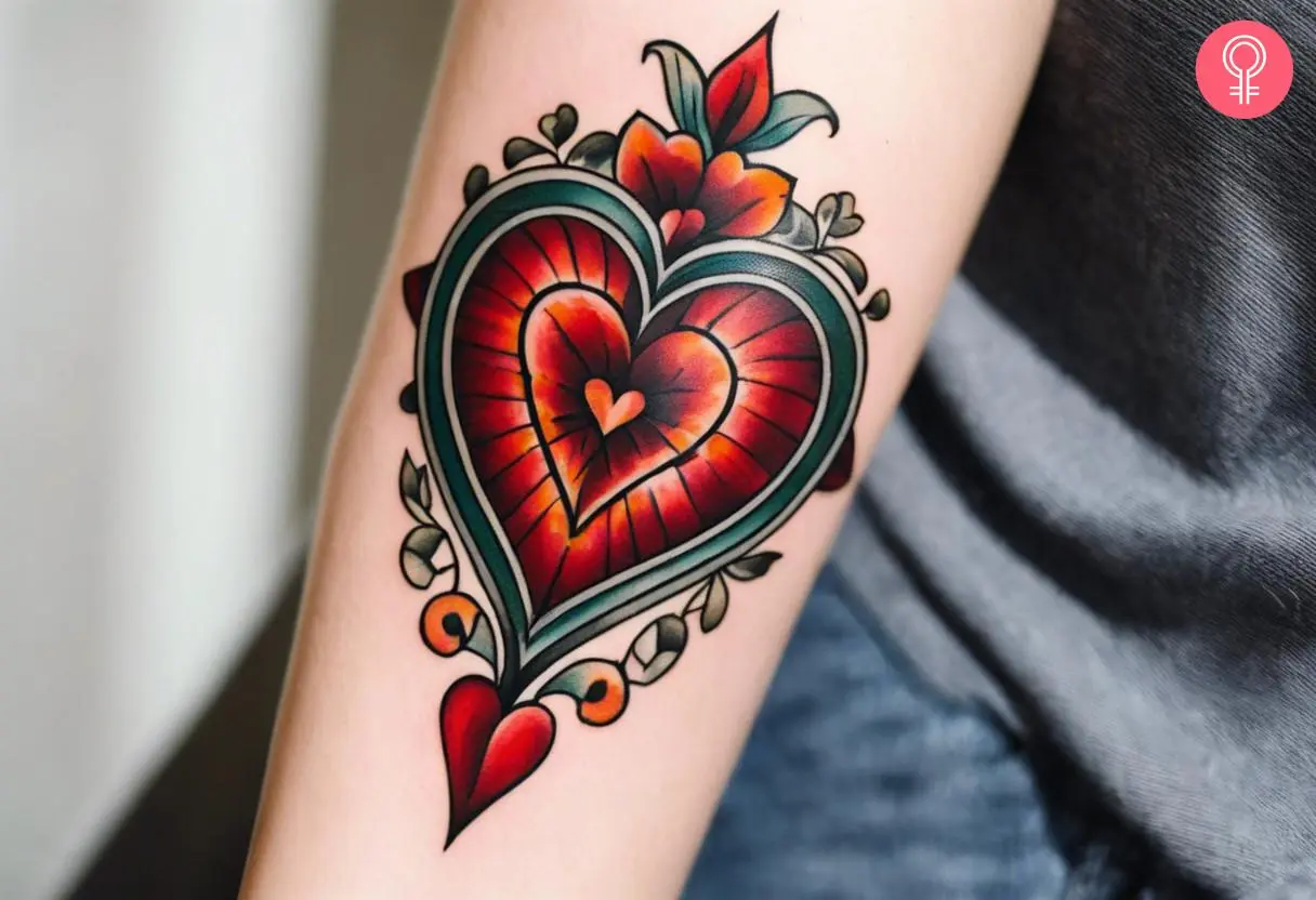 A vintage heart tattoo on the arm of a woman