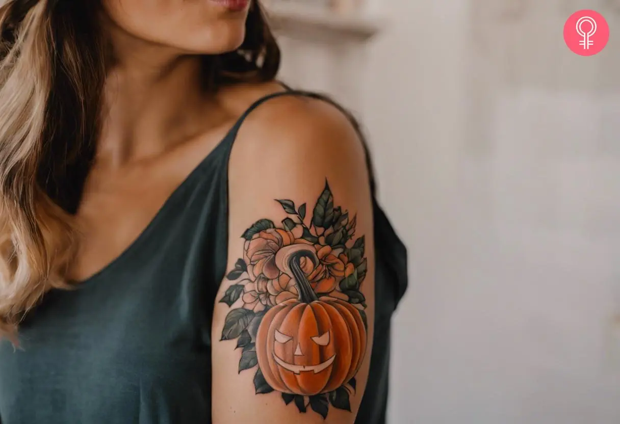 A vintage pumpkin tattoo on the bicep of a woman