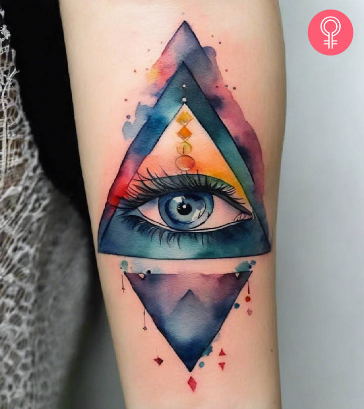 A watercolor Illuminati tattoo on the forearm