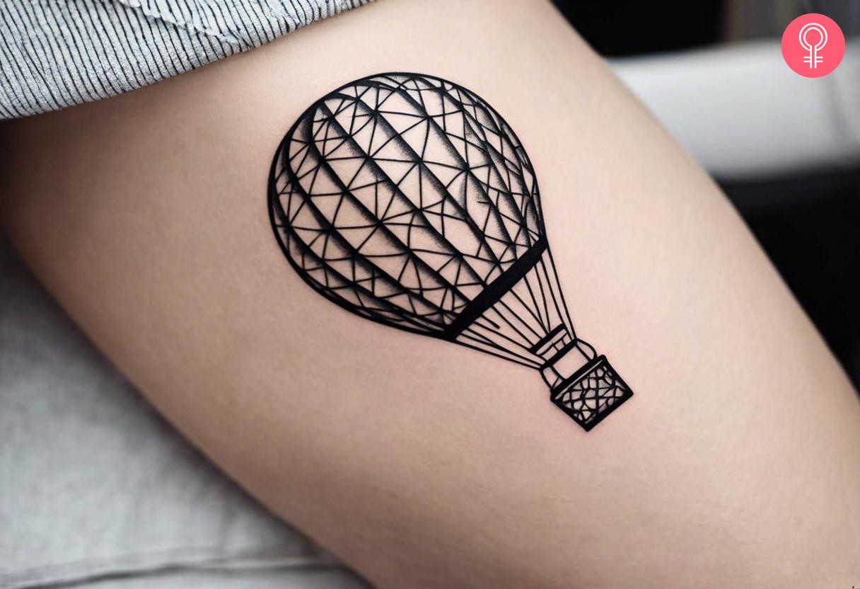 A woman flaunting a geometric hot air balloon tattoo on her thigh