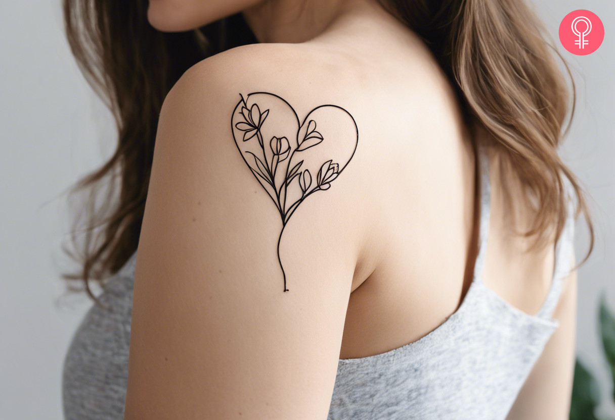 A woman showing a heart and flower tattoo on her shoulder