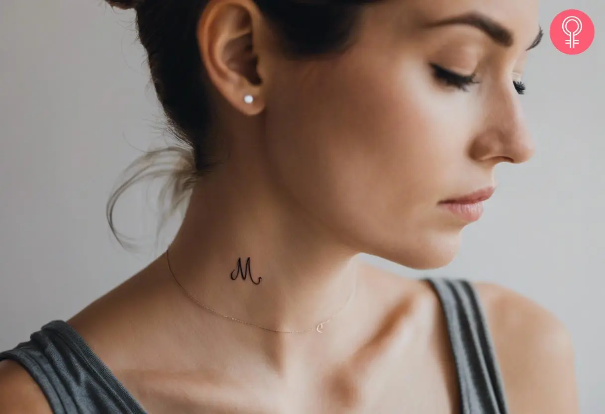 A woman wearing a cursive ‘M’ tattoo on the neck