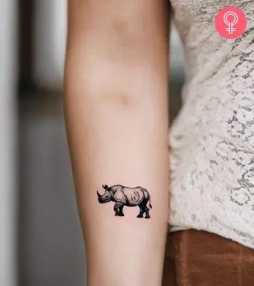 A woman with a black rhino tattoo on her upper arm