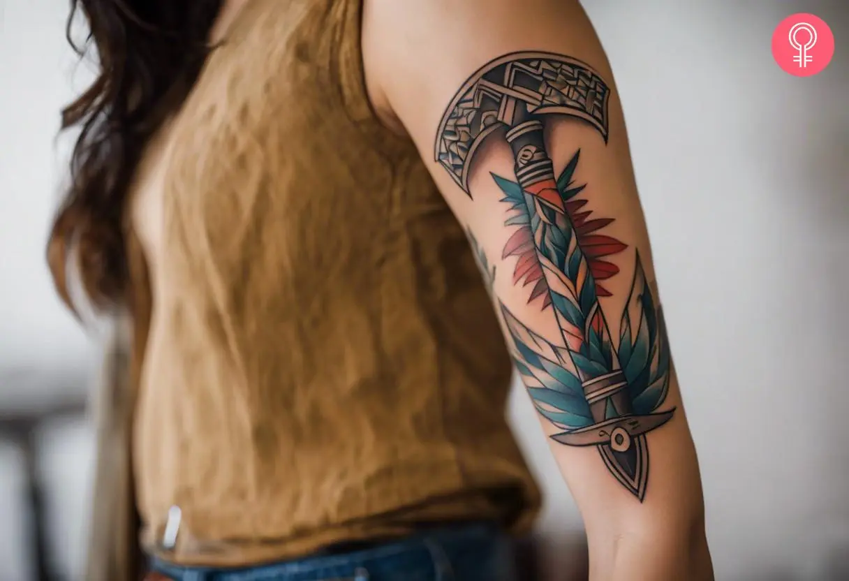 A woman with a colorful tomahawk tattoo on her upper arm