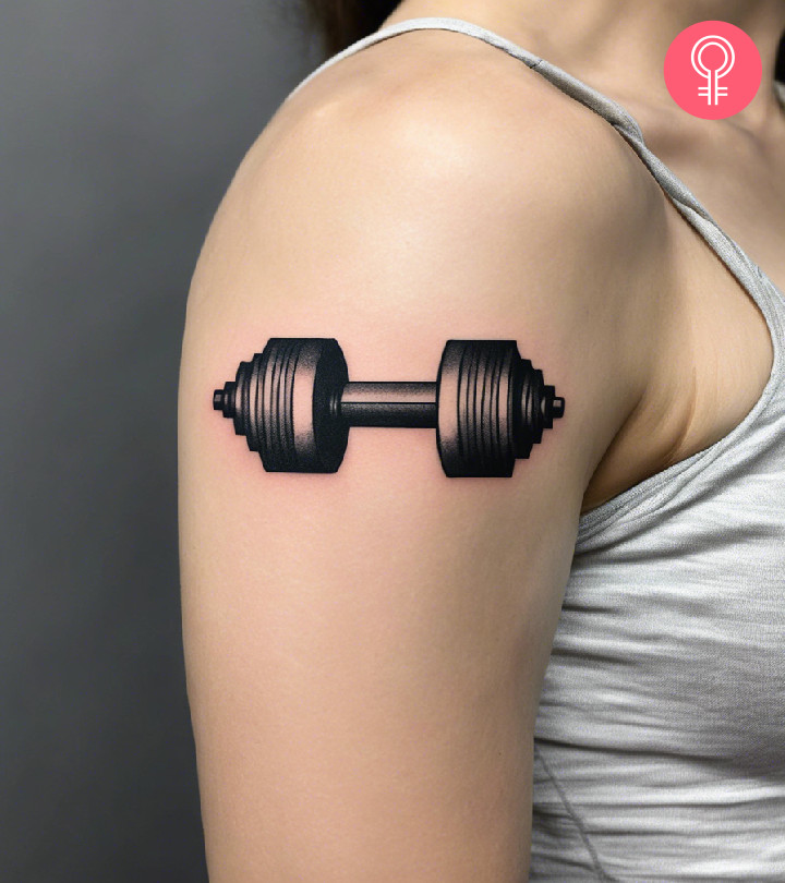 A woman with a dumbbell tattoo on her upper arm