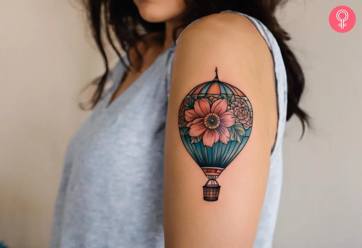 A woman with a flower hot air balloon tattoo on her upper arm