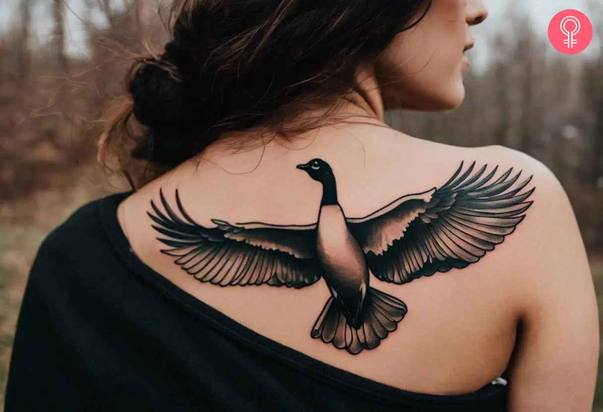 A woman with a flying goose tattoo on her back