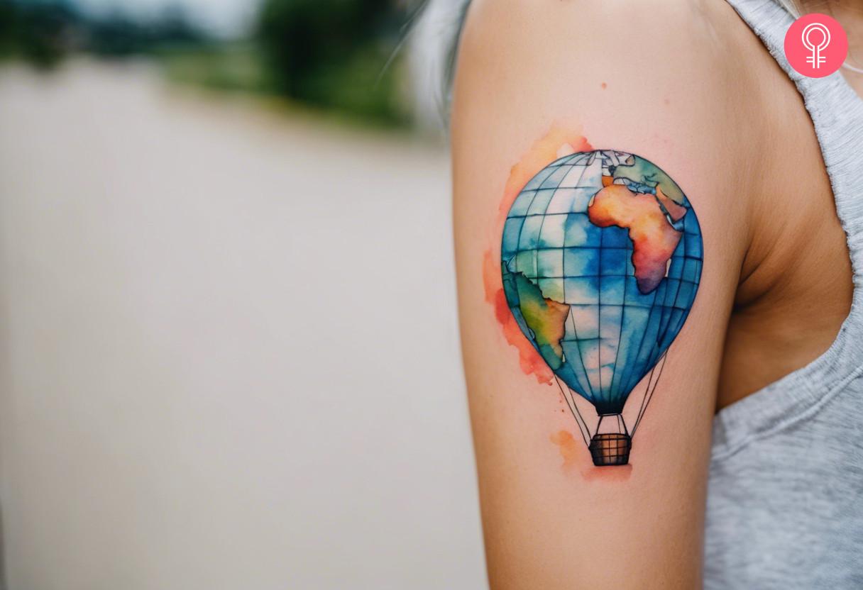 A woman with a tattoo of a globe in the shape of a hot air balloon on her biceps