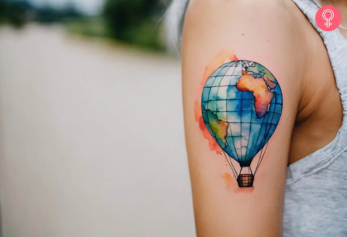 A woman with a globe hot air balloon tattoo on her bicep