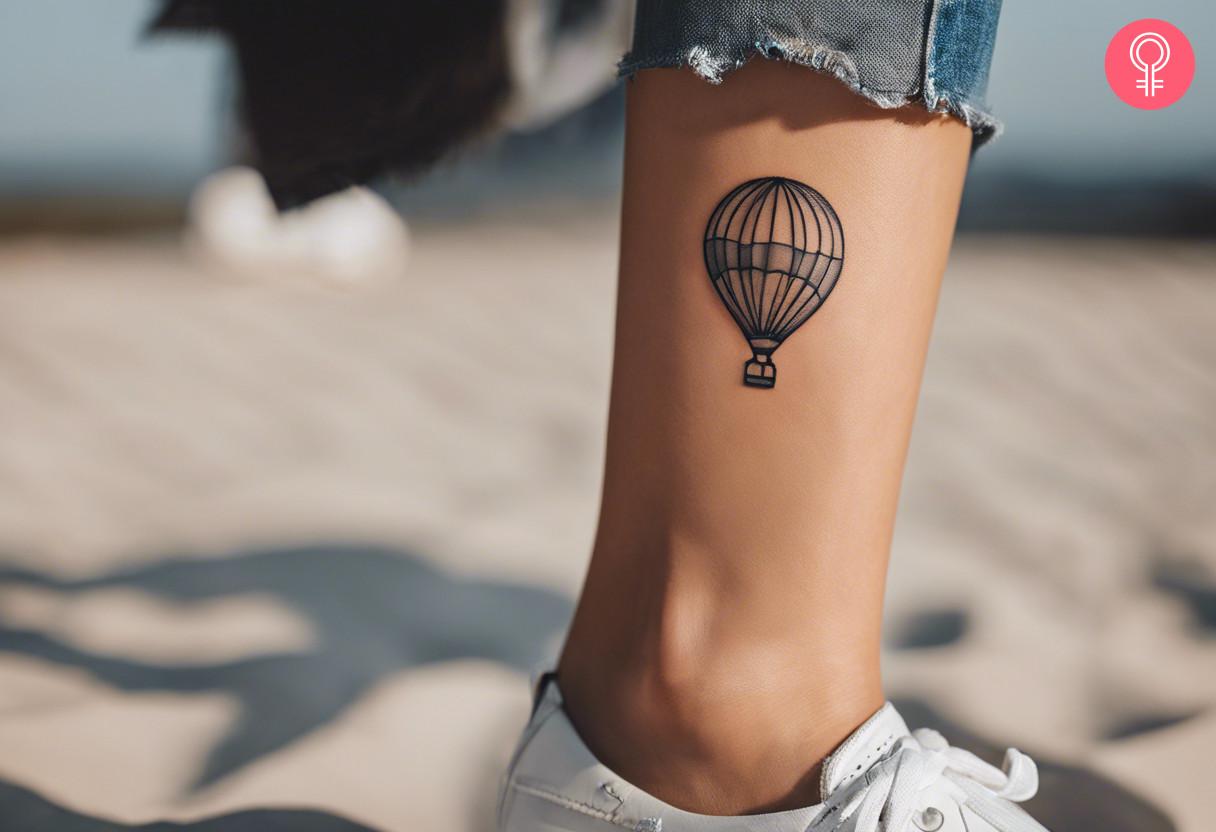 A woman with a minimalist air balloon tattoo on her ankle