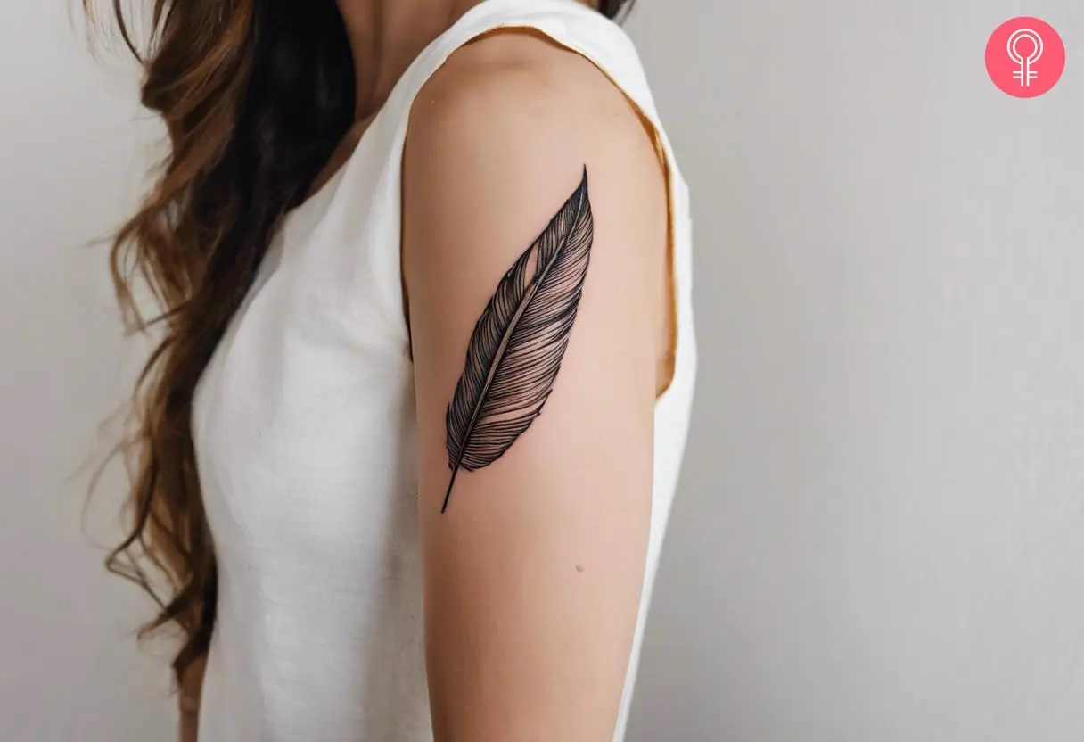 A woman with a minimalist black quill tattoo on her upper arm