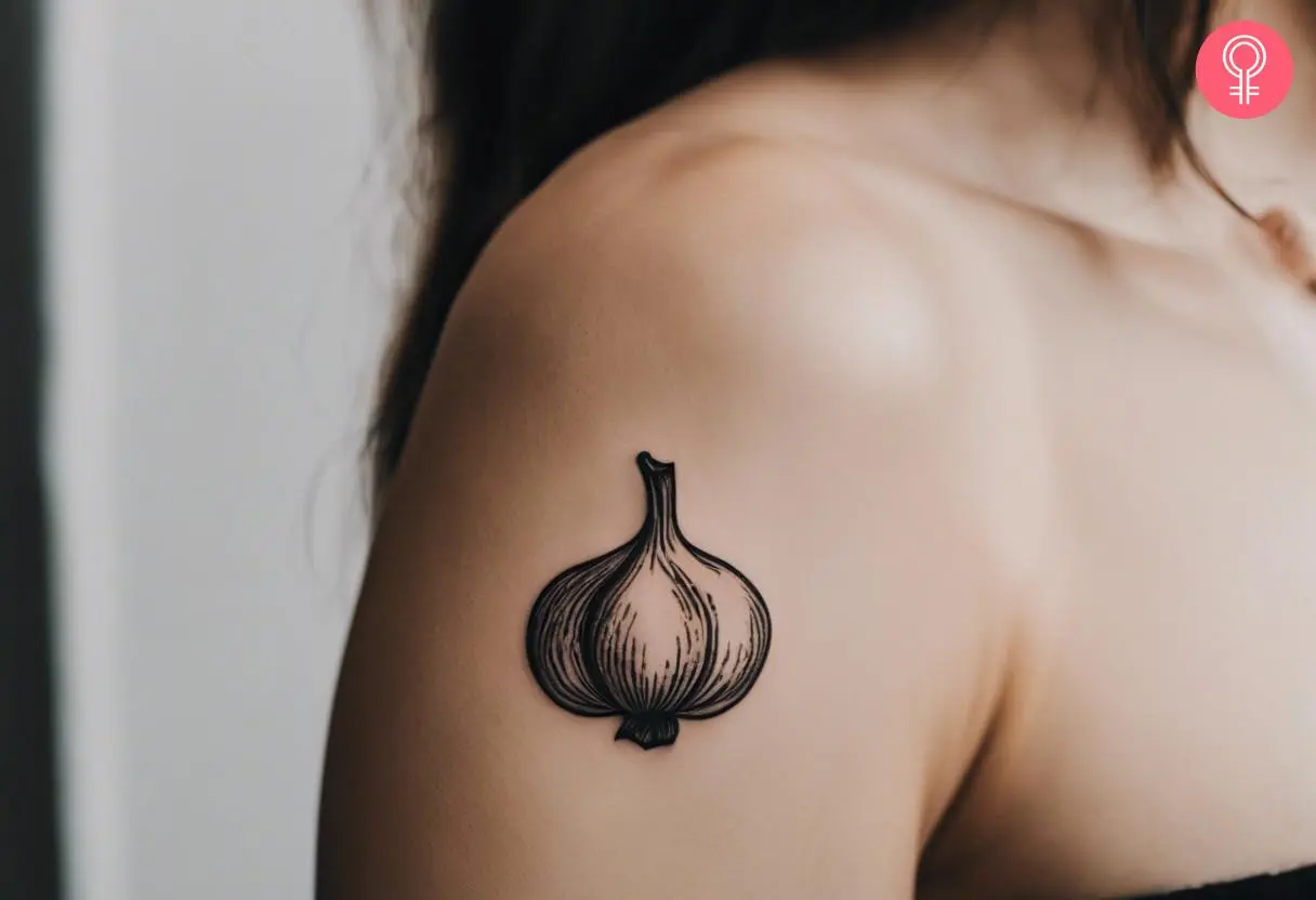 A woman with a minimalist garlic tattoo on her hind arm