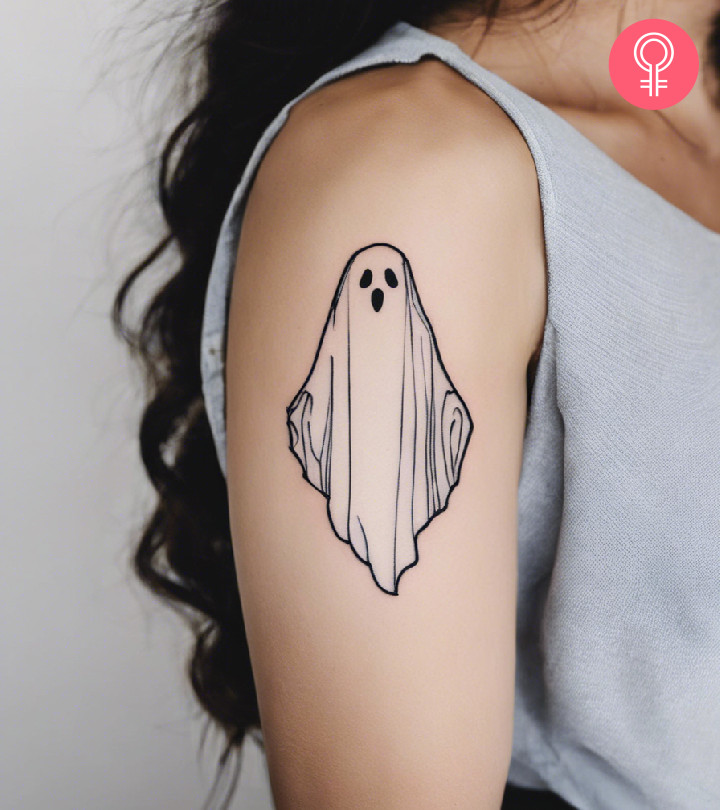 A woman with a minimalist ghost tattoo on her upper arm