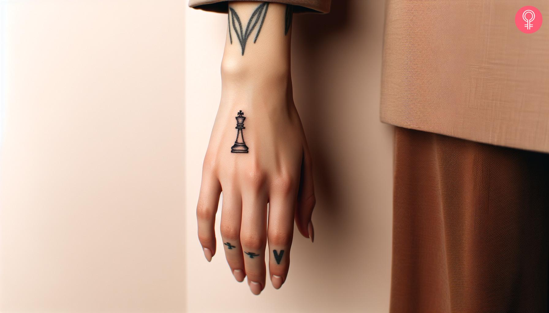 A woman with a queen chess piece tattoo on her hand