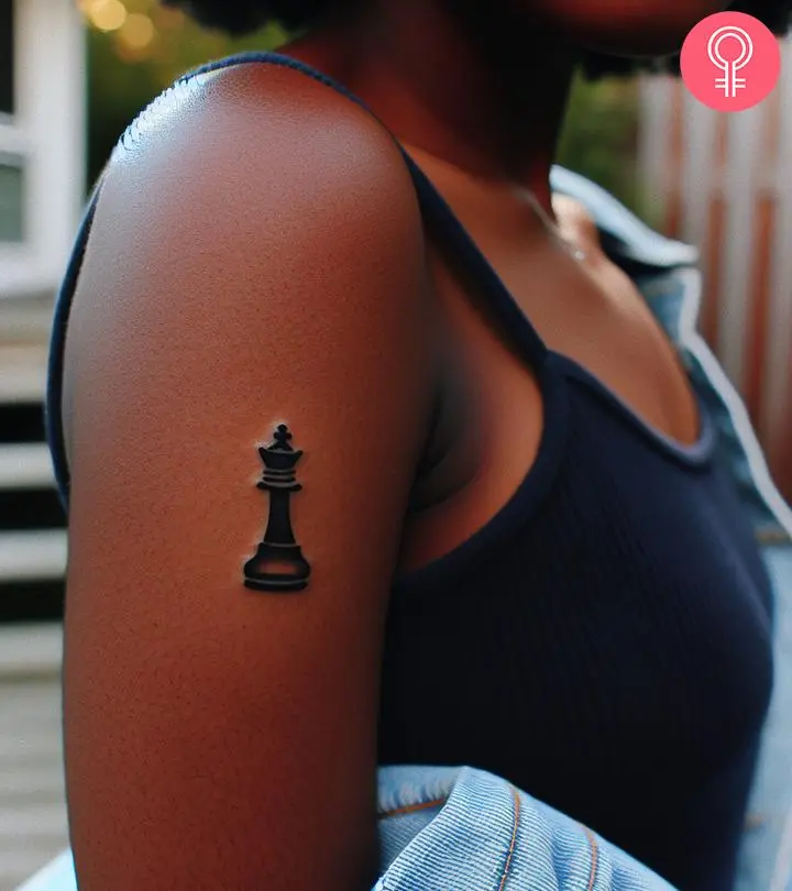 A woman with a queen chess piece tattoo on her upper arm