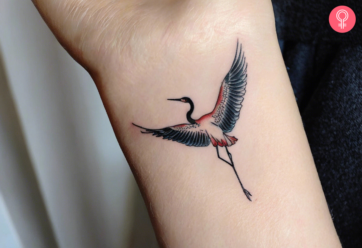 A woman with a small Japanese crane tattoo on her arm