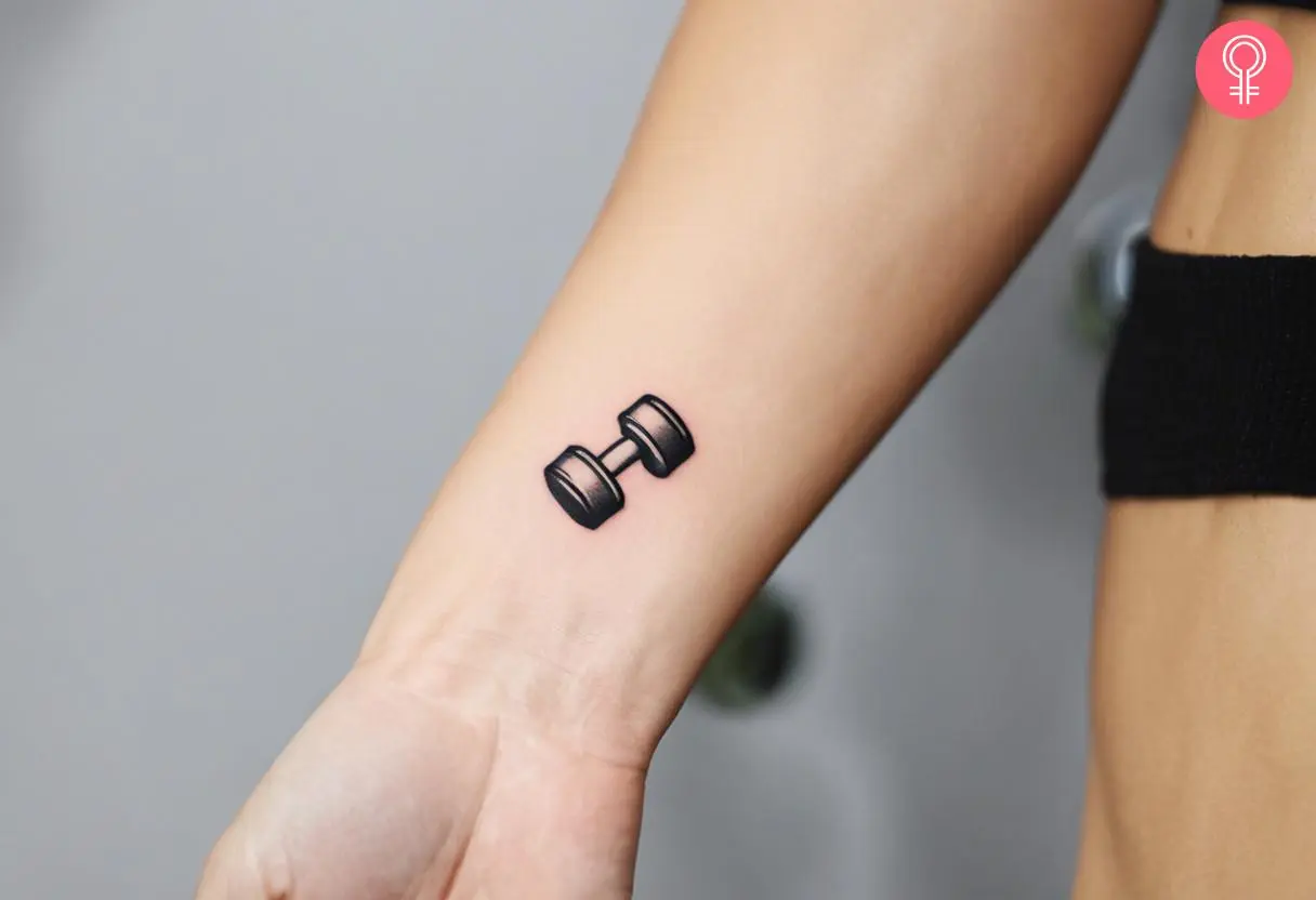 A woman with a tiny dumbbell tattoo on her wrist