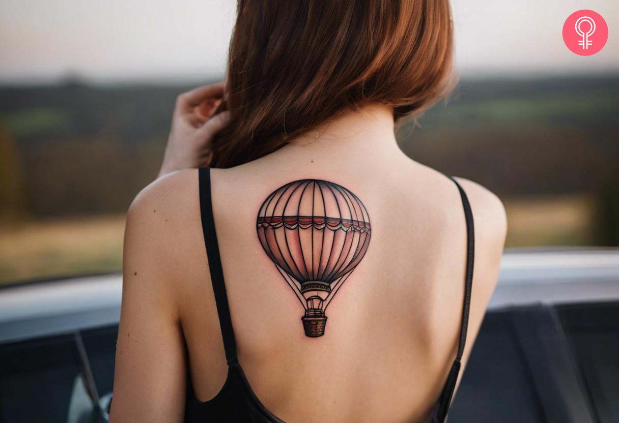 A woman with a traditional hot air balloon tattoo on her upper back