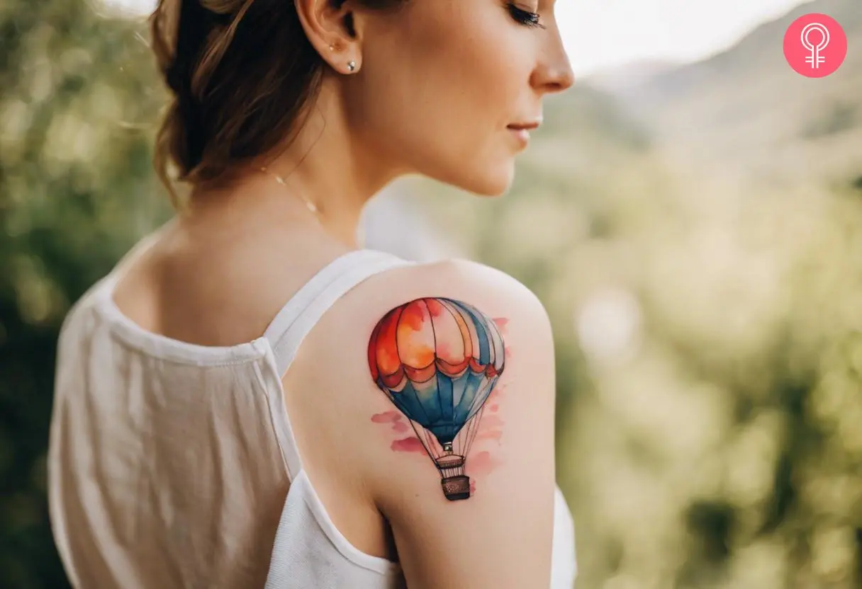 A woman with a watercolor hot air balloon tattoo on her shoulder