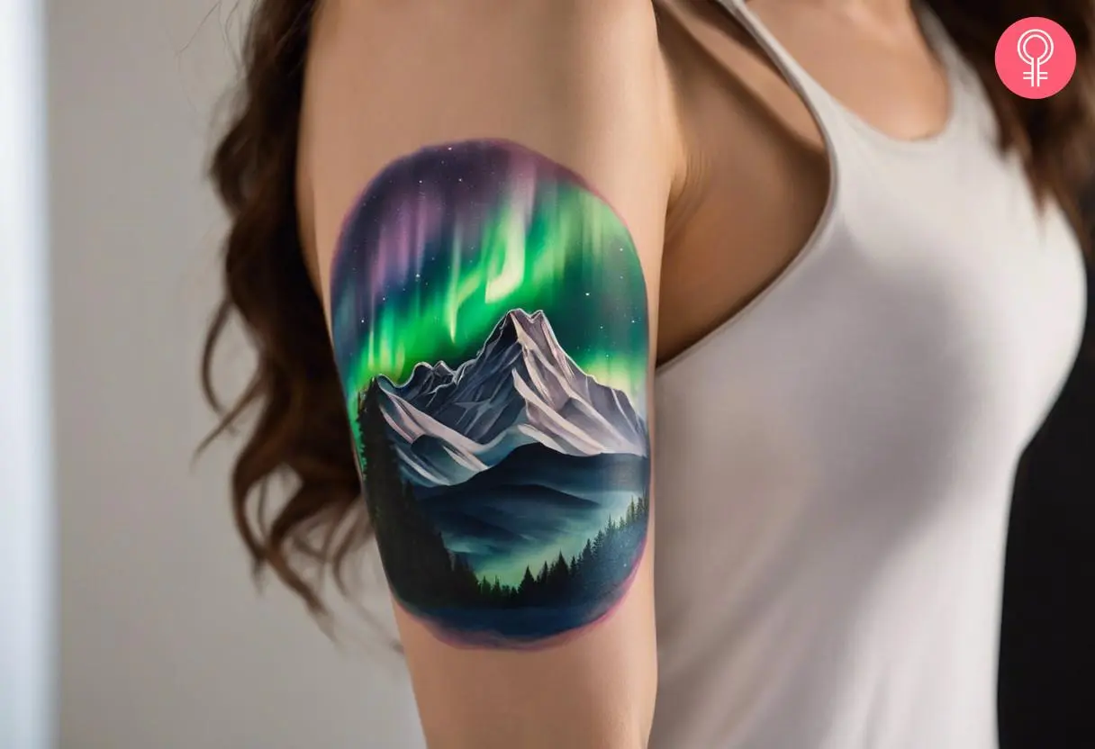 A woman with vibrant aurora borealis and mountains tattoo on her upper arm