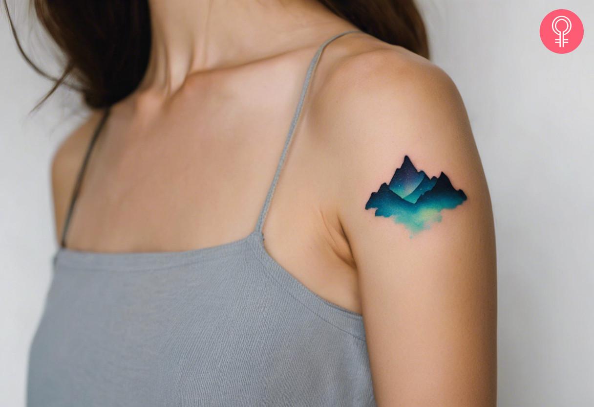 A woman with vibrant aurora borealis tattoo on her upper arm