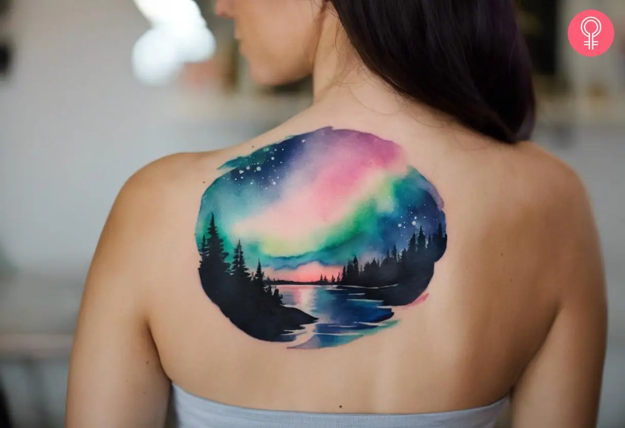 A woman with watercolor aurora borealis tattoo on her upper back