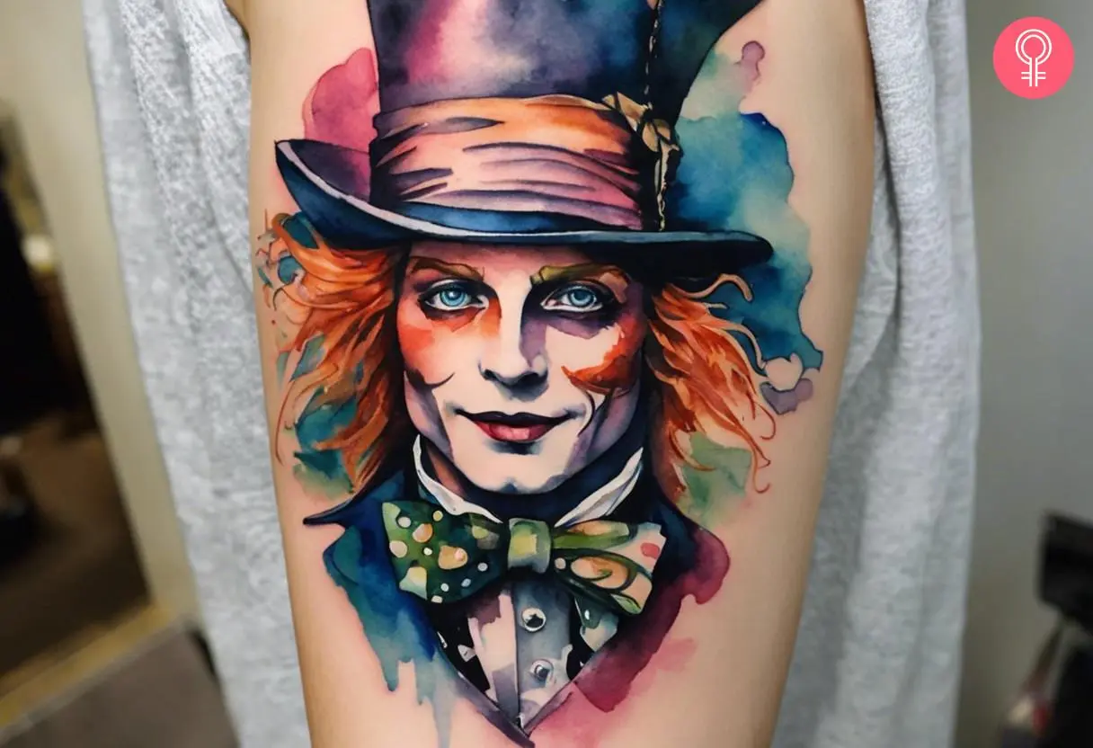 An Alice in Wonderland Mad Hatter tattoo on a woman’s upper arm