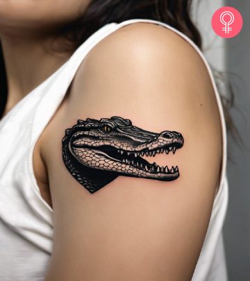 Woman with a crocodile tattoo on the upper arm