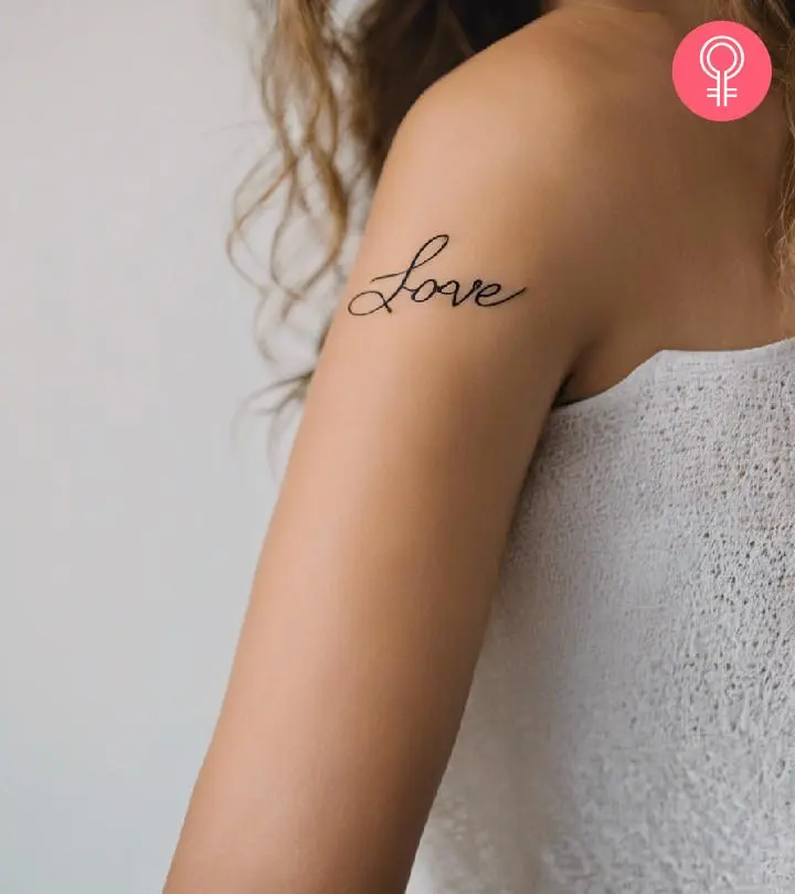 A cursive love tattoo on the upper arm.