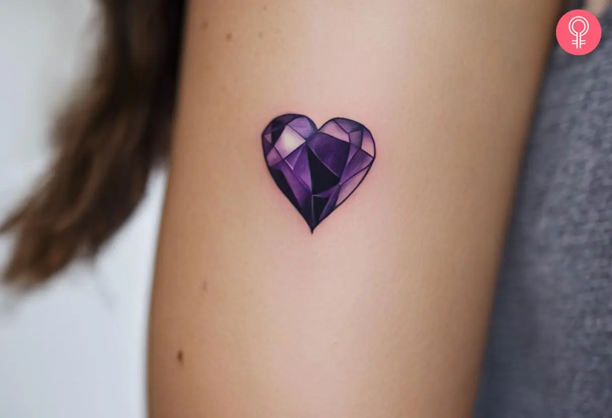 A woman with an amethyst heart tattoo on her upper arm