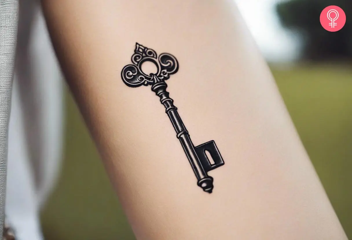 An antique key inked on the forearm