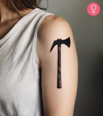 An axe tattoo on a woman’s arm