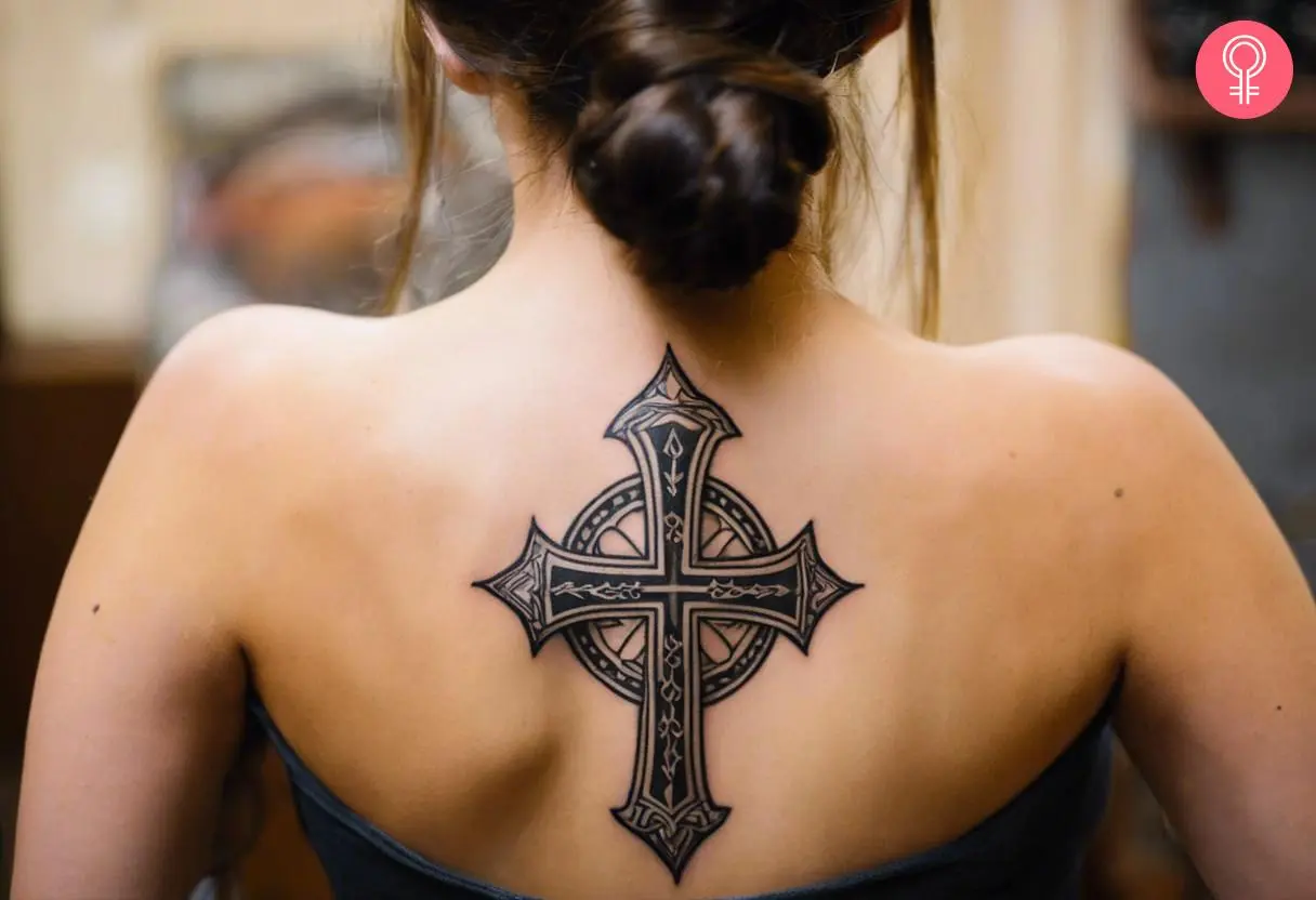 An intricate and pretty Cross tattoo on the back