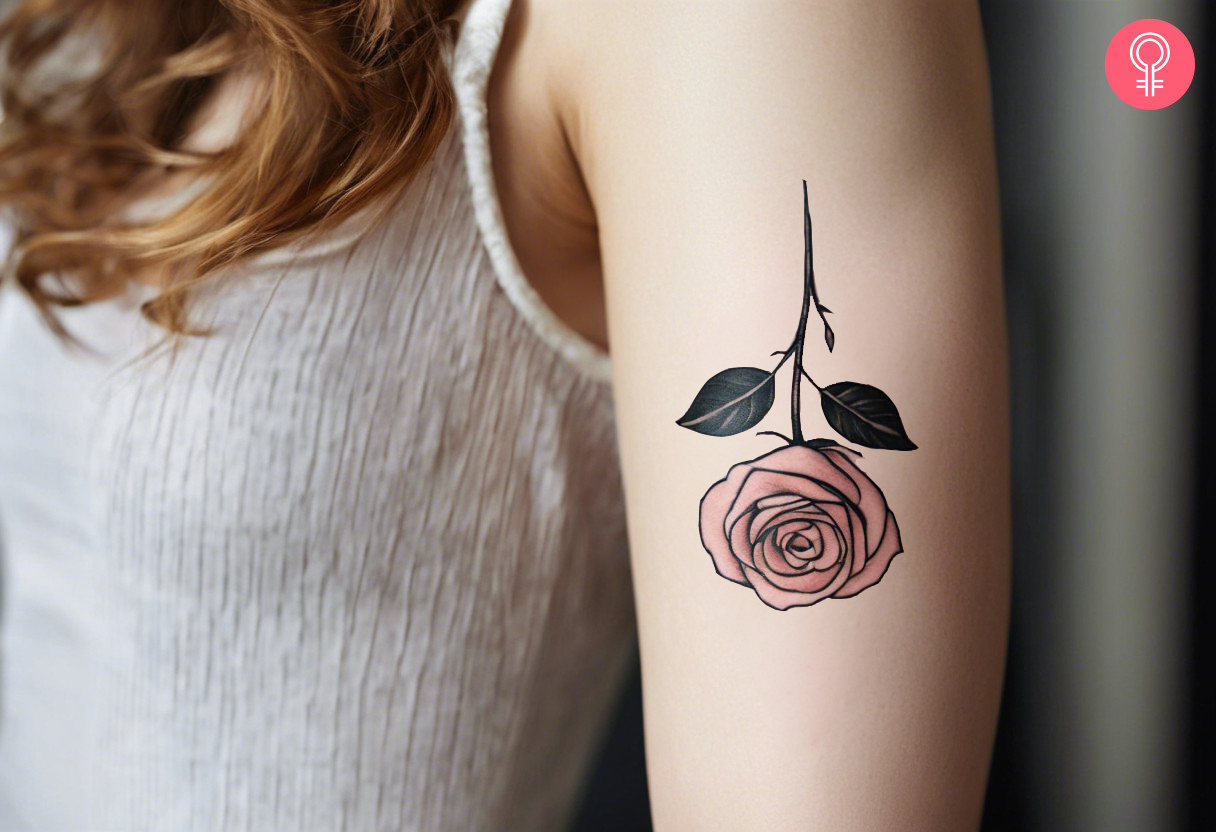 An inverted rose tattoo on a woman’s upper arm