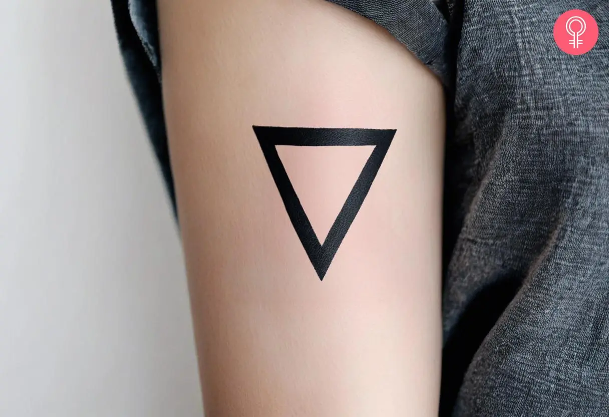 An inverted triangle tattoo on a woman’s upper arm