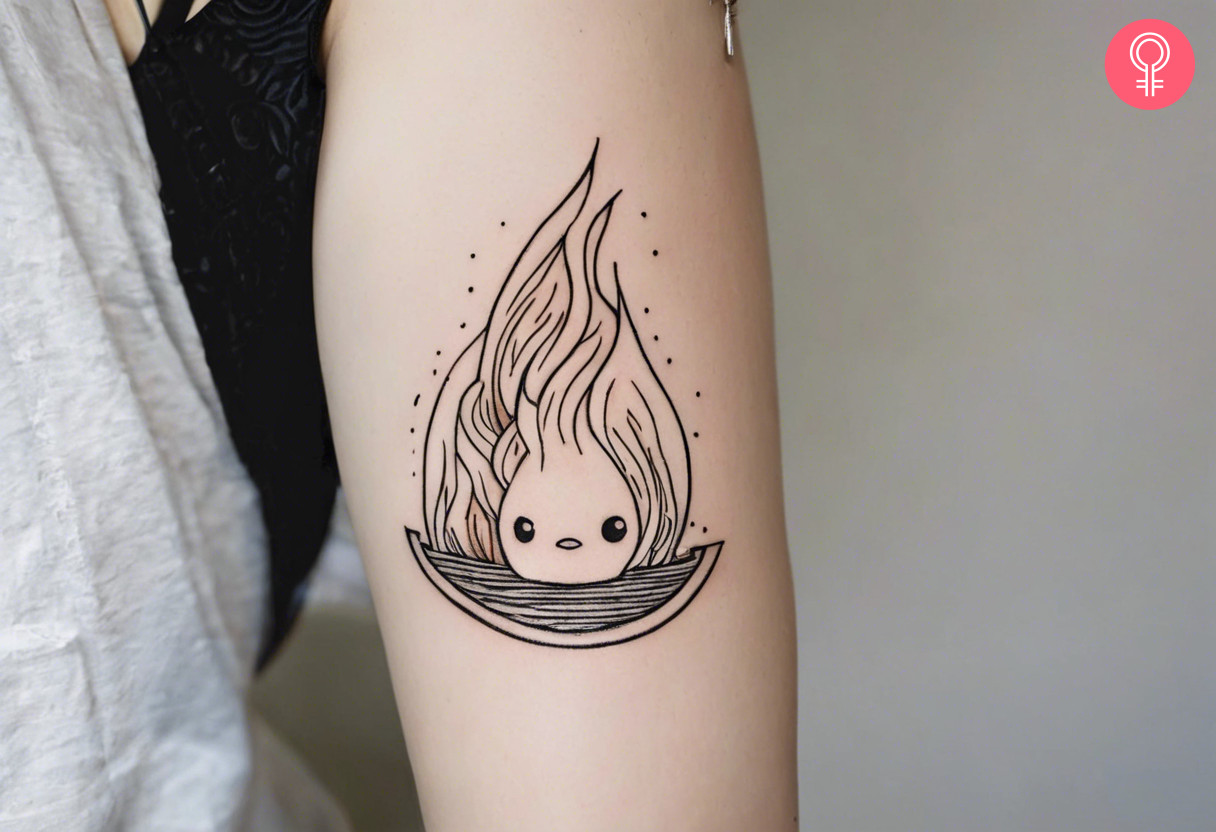 An outline tattoo of Calcifer on the upper arm