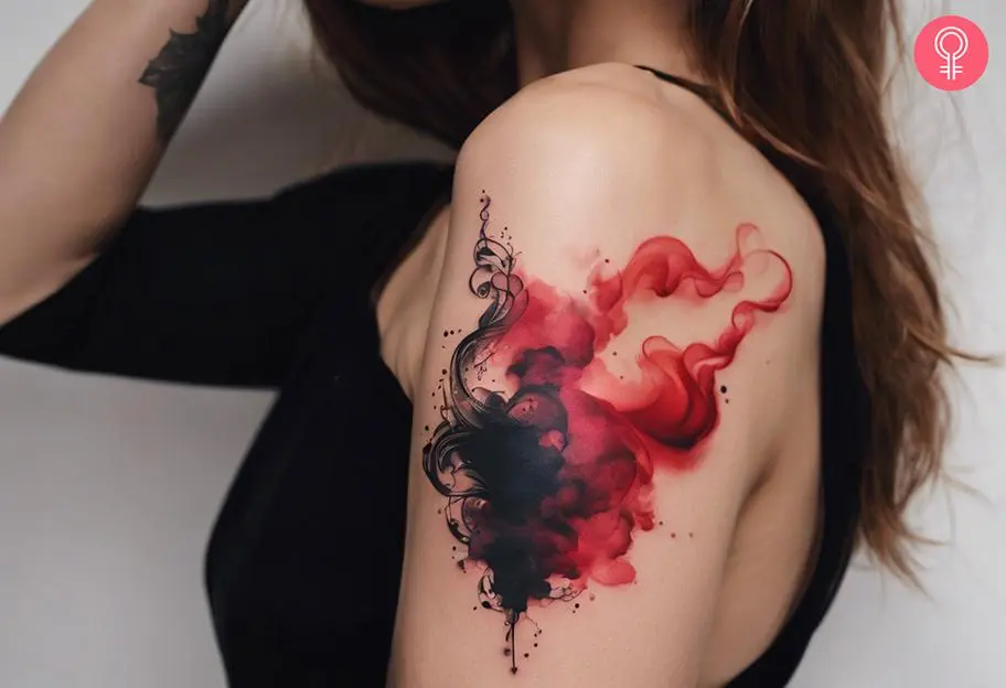 An outline tattoo of smoke on a woman's upper arm