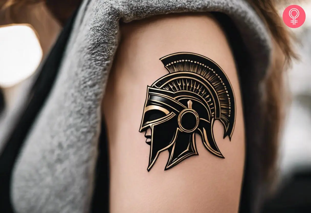 Authentic spartan helmet tattoo on a woman’s upper arm