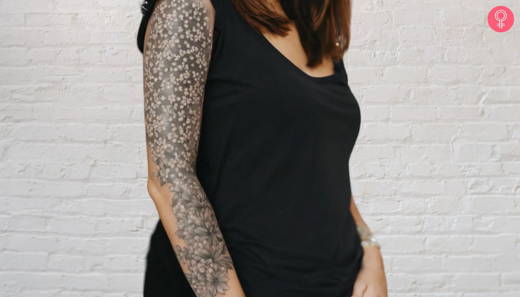 A woman with a baby’s breath sleeve tattoo