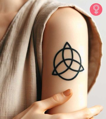 A woman sporting a trinity knot tattoo on the upper arm